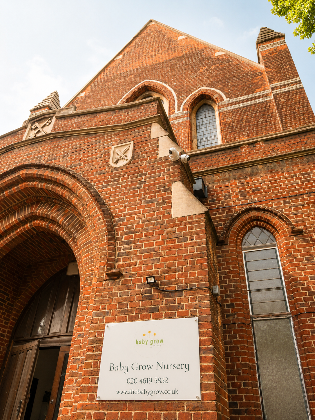 The historic red-brick exterior of Baby Grow Nursery, set in St Peter's Church, Fulham